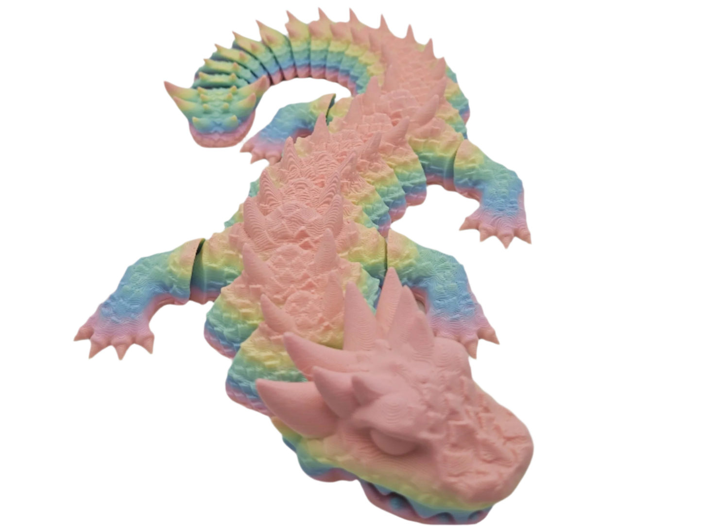 A rainbow-colored dragon lies in a prone position, its limbs splayed out and its head facing downward. The background is black.