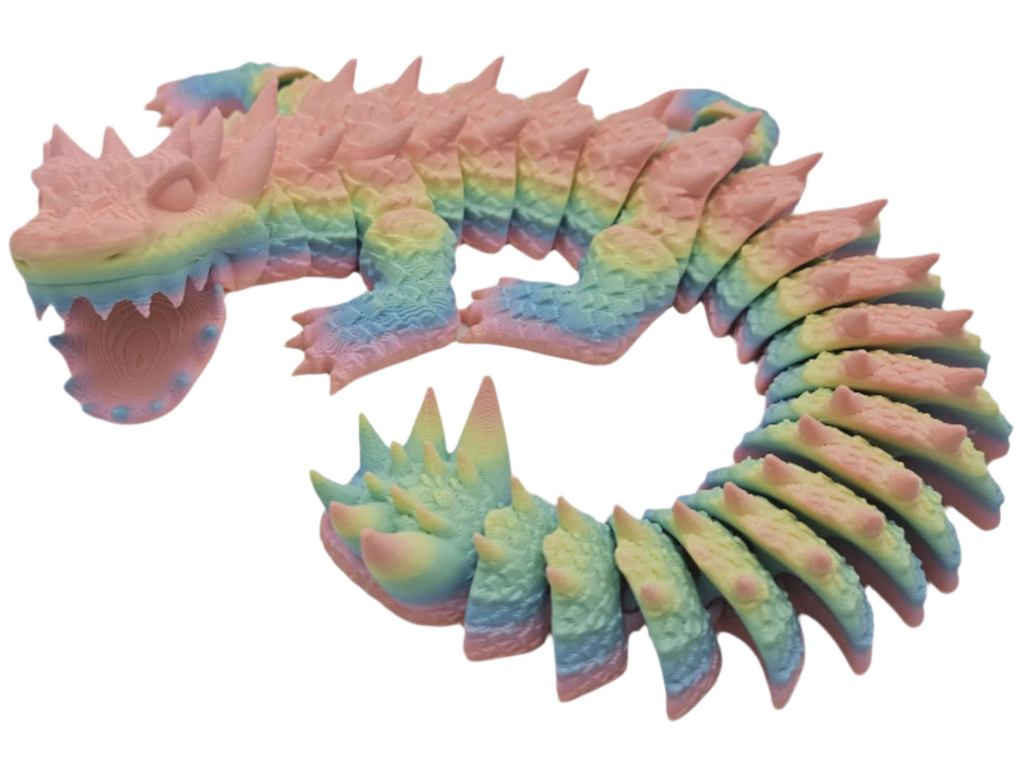 A segmented, rainbow-colored dragon toy with spikes is curled into a loop, set against a black background.