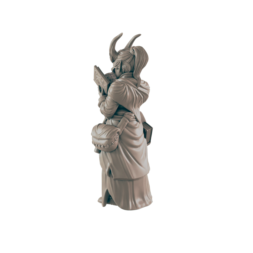 A miniature figurine of a horned woman, reading a book, stands against a dark background. The text on the book is partially visible.