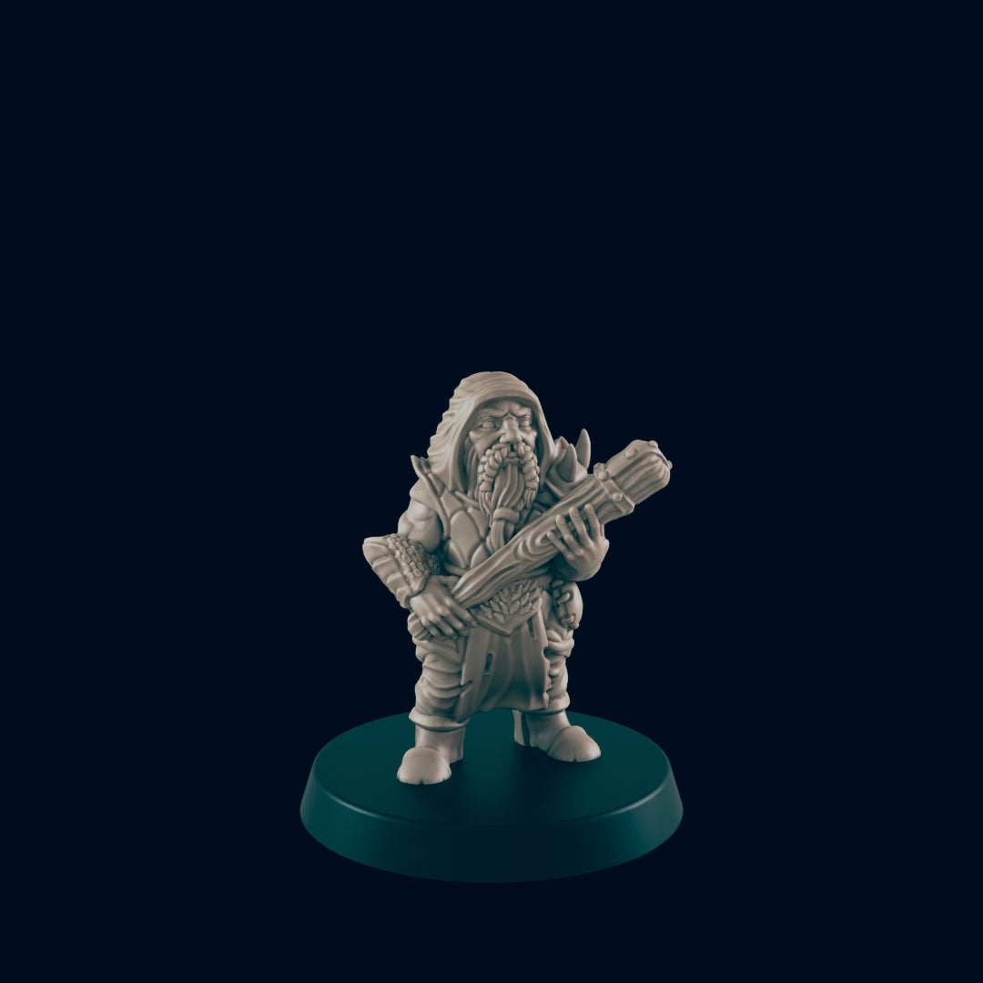 A miniature dwarf figure stands holding a bundle of wood, posed on a black base. The background is solid black.