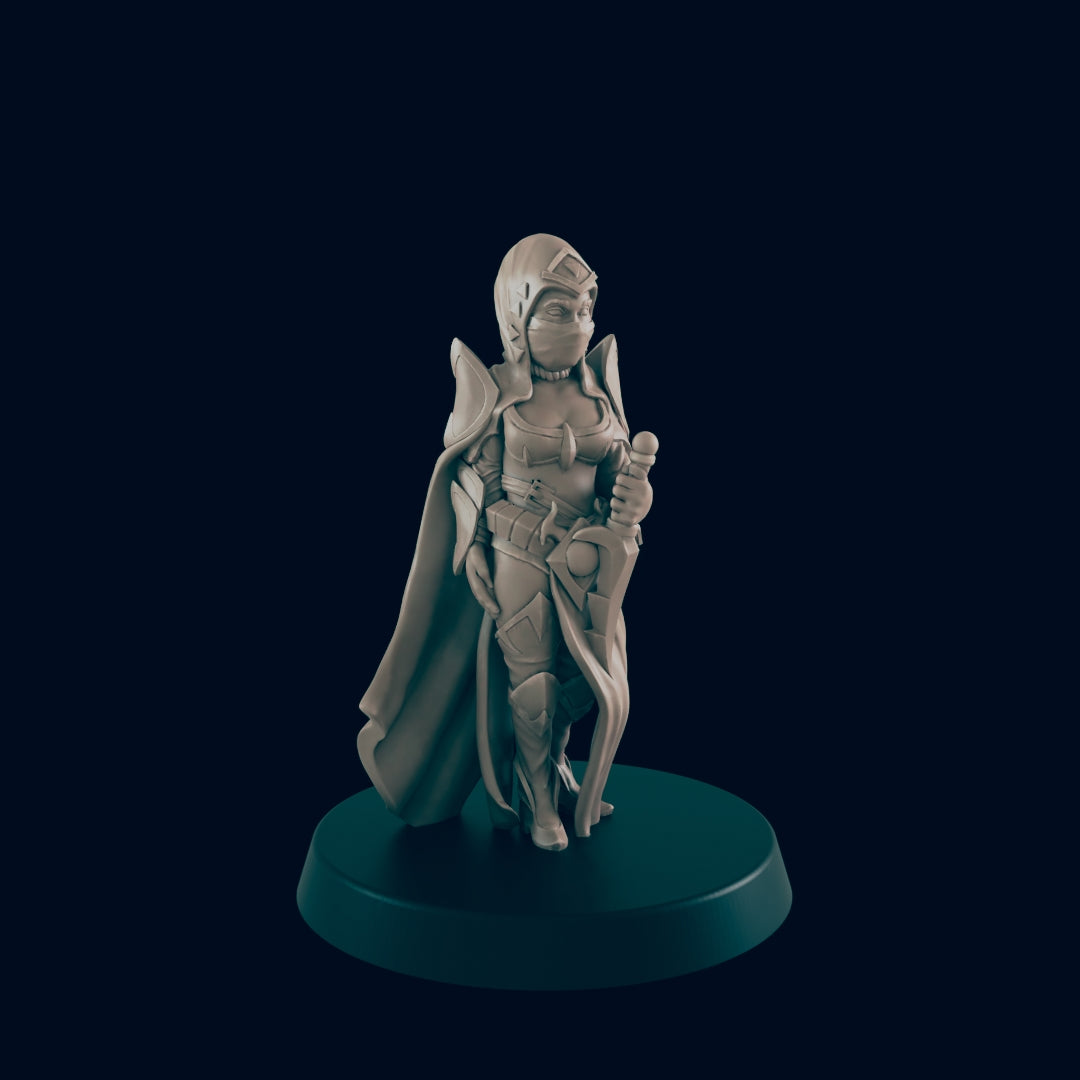 A miniature figure stands on a base, holding a sword at her side. She wears a cape, hood, and mask in a dark, blank space.