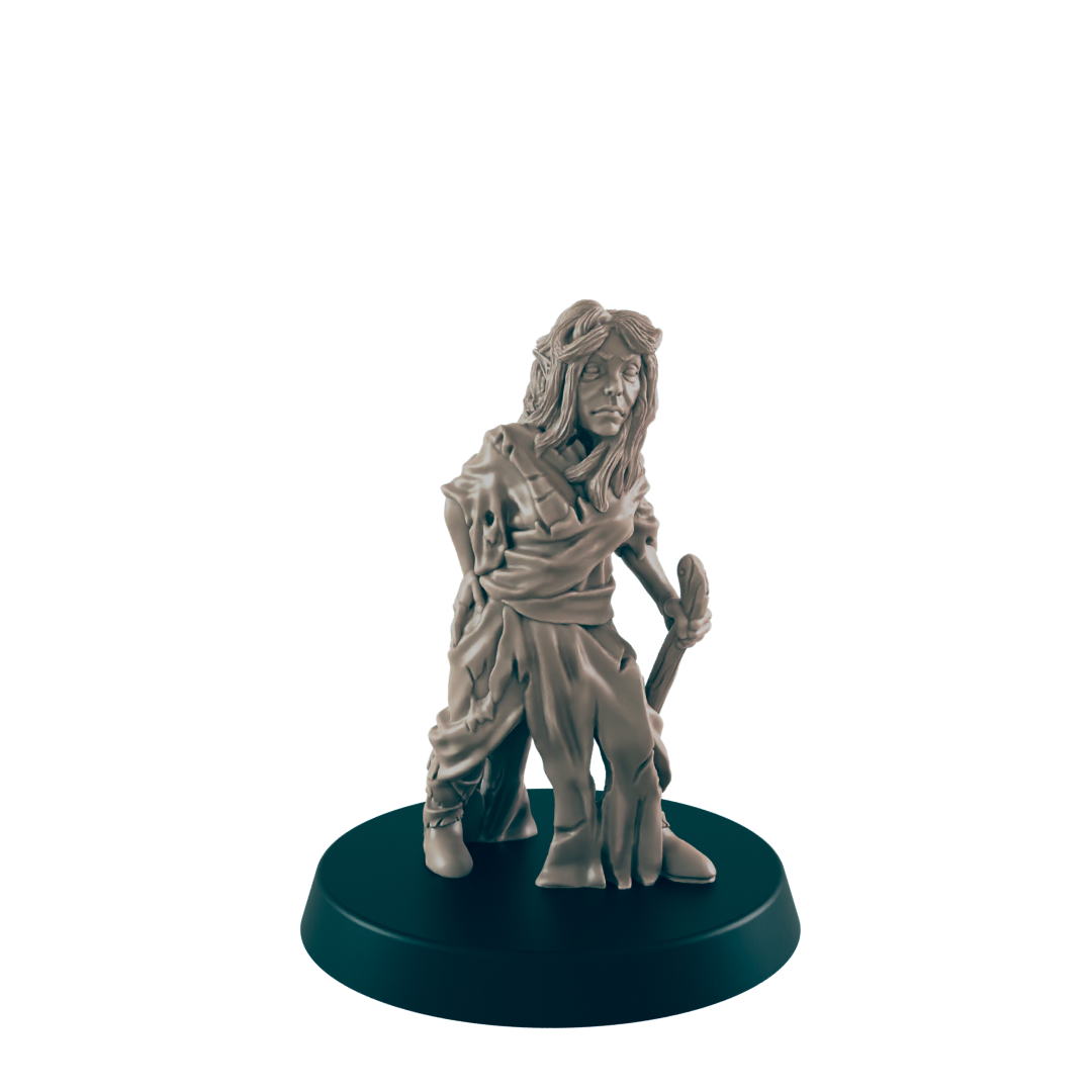 A miniature figurine of a woman, appearing weathered and holding a staff, stands on a dark circular base against a dark background.
