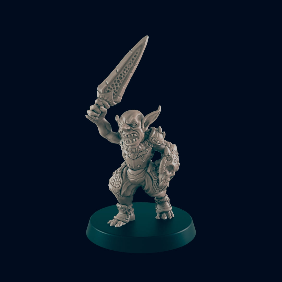 A grey figurine of a goblin raises a sword high in the air, standing aggressively on a circular platform, set against a plain dark blue background.