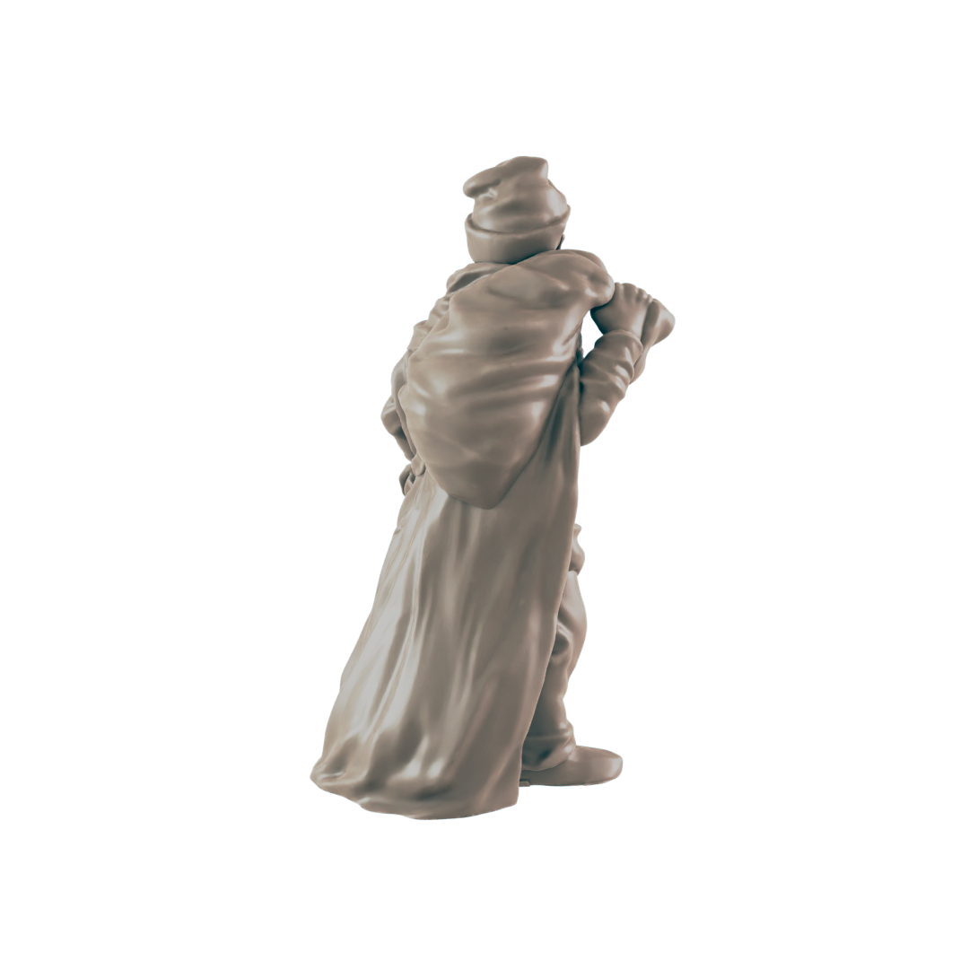 A miniature figurine of a cloaked figure carries a large sack on their back against a dark background.