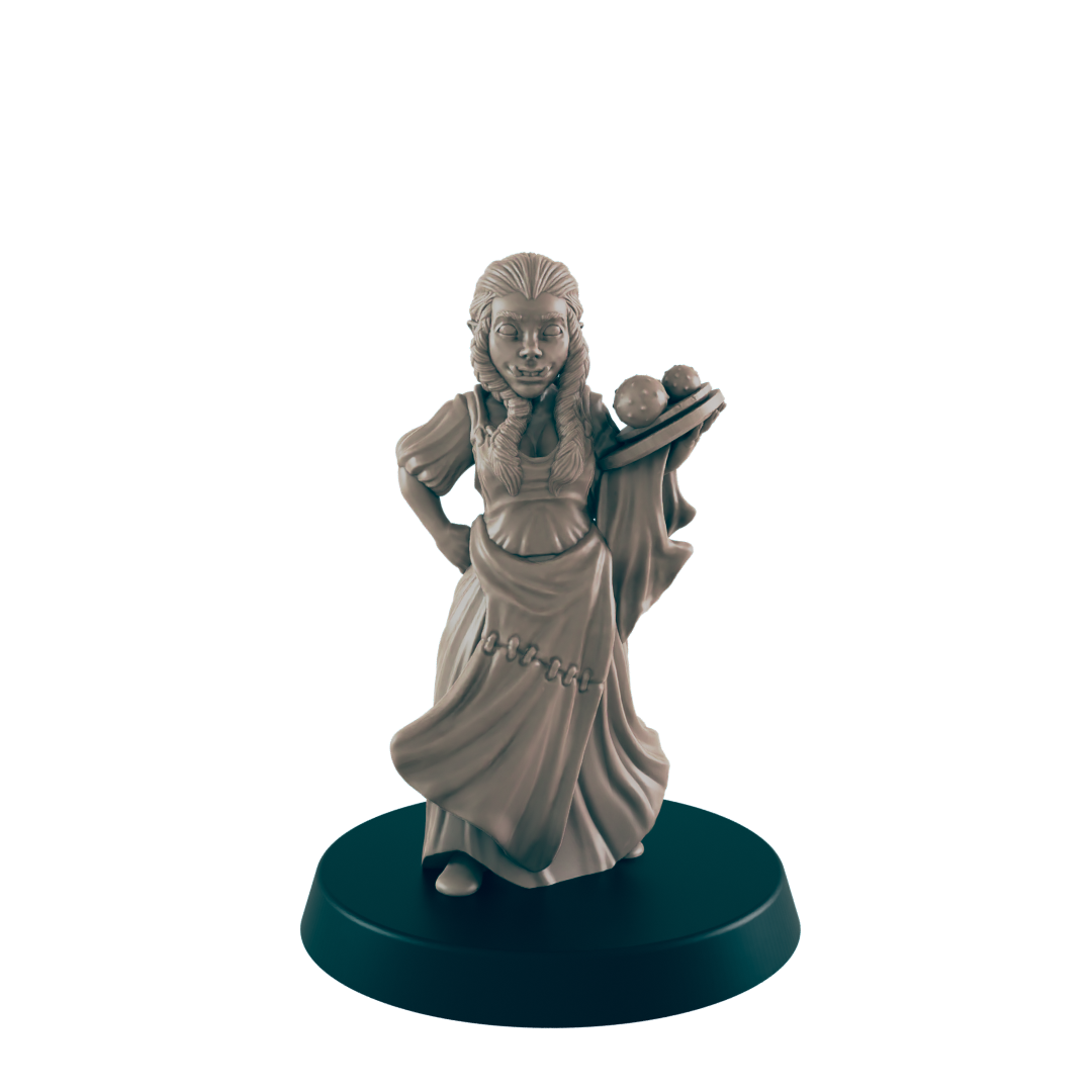 A miniature, light-brown female figure, dressed in peasant-style clothing, holds a tray of spherical objects. The figure stands on a black, circular base against a black backdrop.