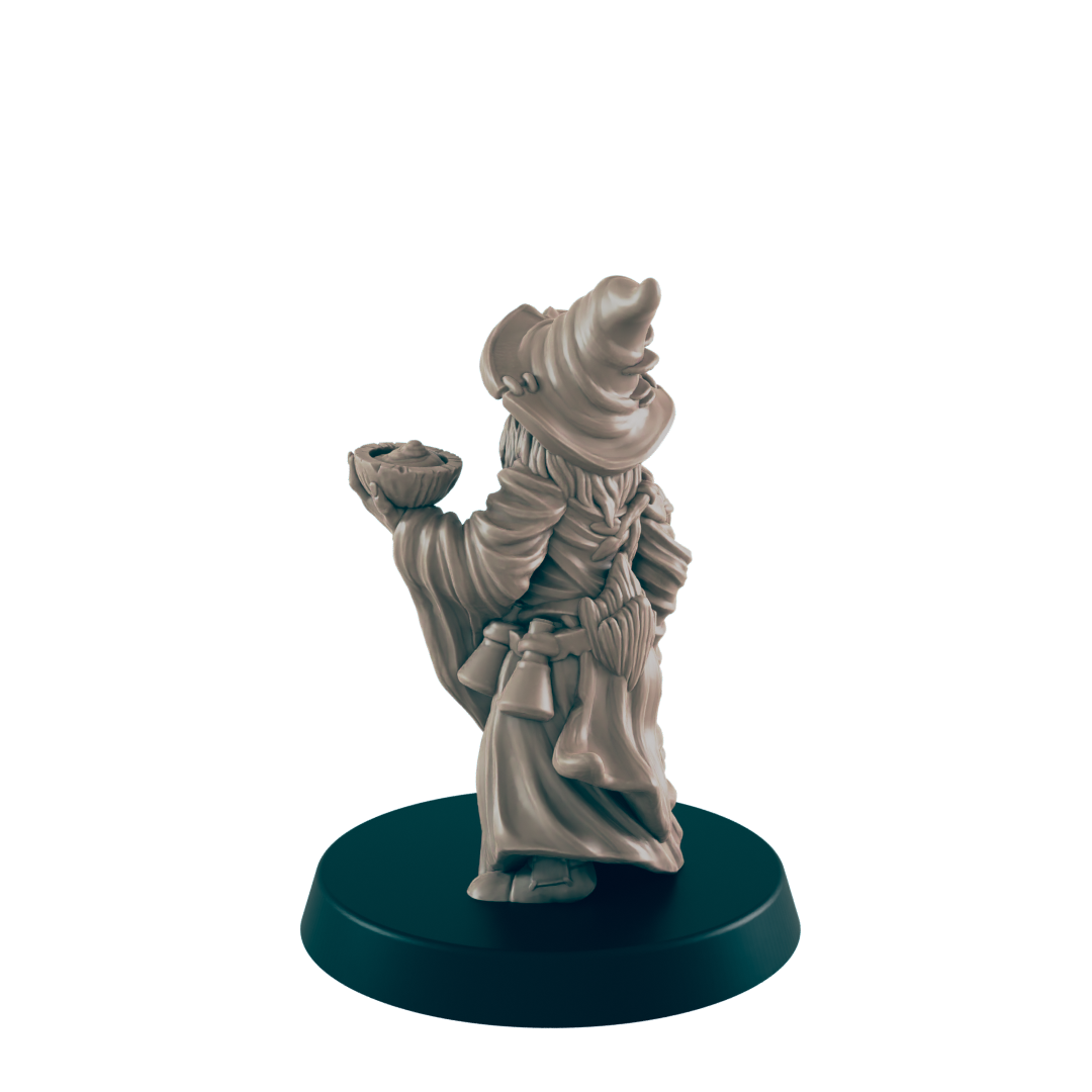 A miniature wizard figurine holds a bowl, stands on a dark base.