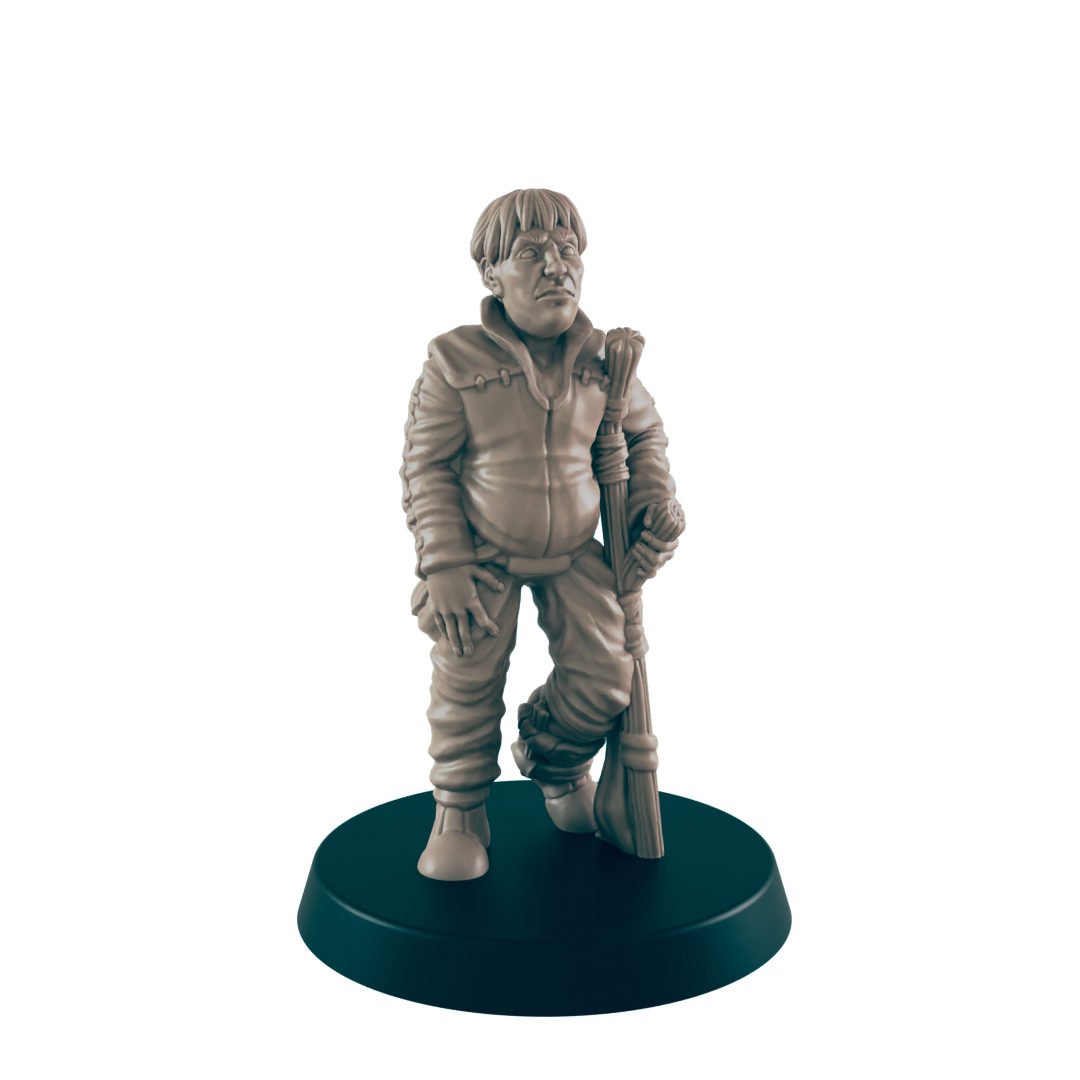 A miniature figurine of a stout boy stands, holding a staff; it is displayed on a dark circular base.