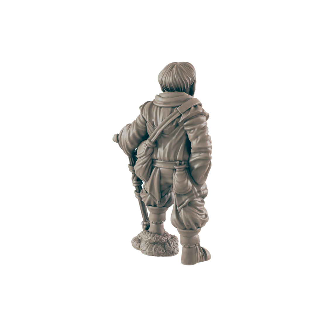 A miniature figurine of a traveler, standing with a staff, wears a hooded cloak and satchel against a dark background.