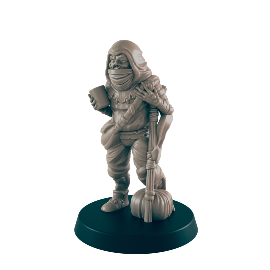 A miniature goblin figure stands on a dark base, holding a cup and a staff with a gourd. It wears a hooded cloak and tattered clothing.