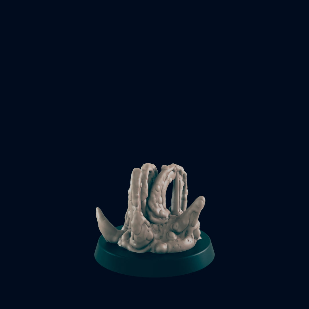 A beige, organic-looking sculpture, resembling a bubbling mass or creature, sits on a dark circular base against a black background.