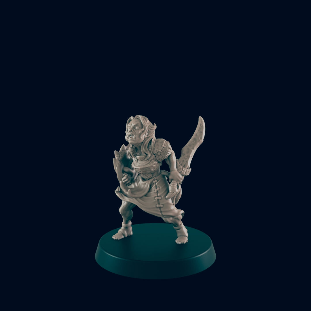 A miniature orc woman figure stands defensively, wielding a sword and shield, on a dark circular base.