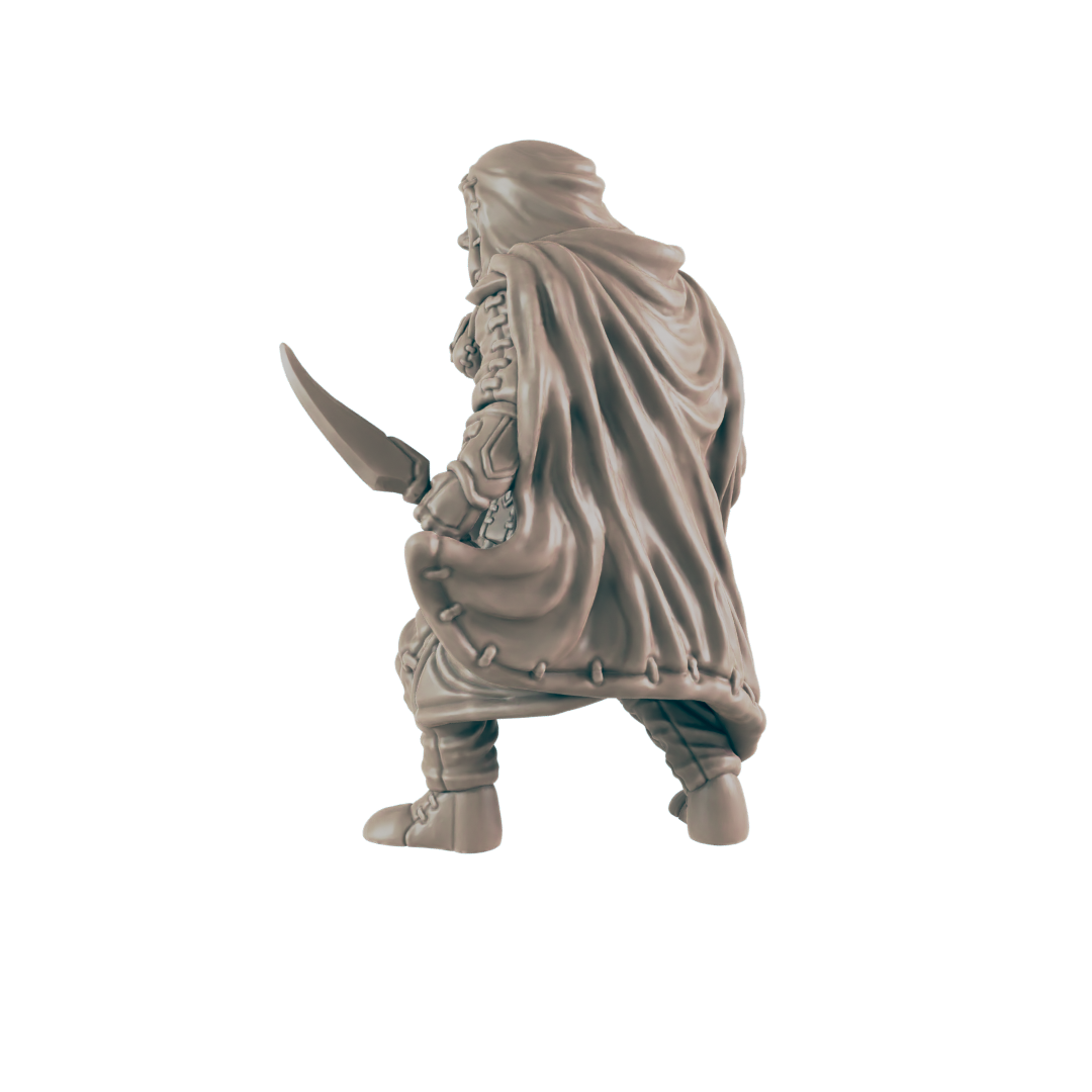 A miniature figure kneels, facing away, in a black void, holding a sword. The figure wears a hooded cape and armored boots.