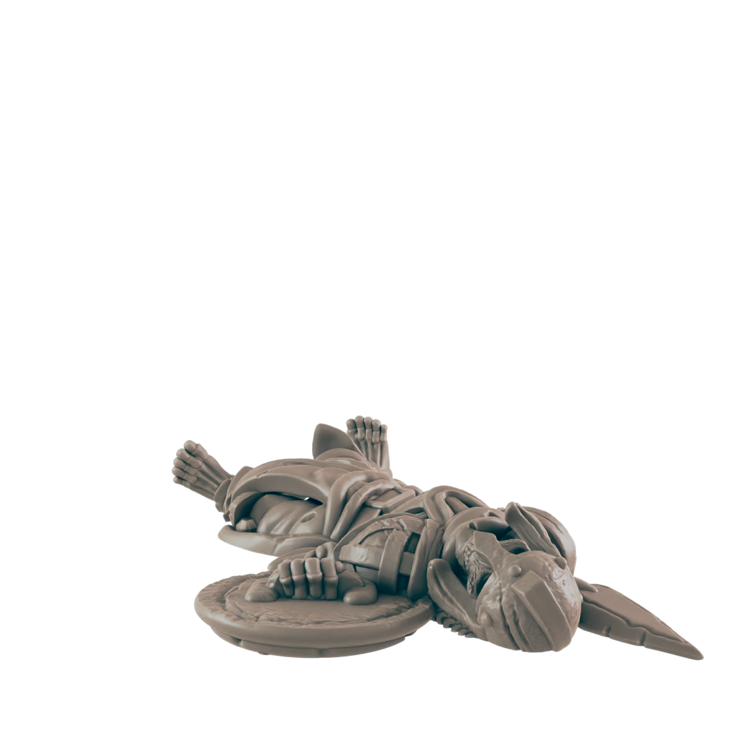 A skeletal warrior miniature lies supine; it holds a shield, on a dark background.