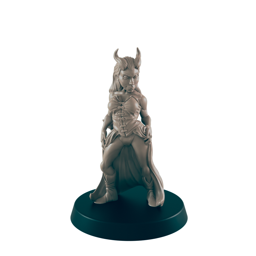 A miniature female figure, horned and cloaked, stands on a round base. The figurine is sculpted in a pose suggesting confidence or defiance. The setting is a dark background, highlighting the sculpture.