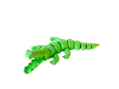 A neon green toy alligator with an open mouth sits on a black background. Its body is made of segmented pieces.