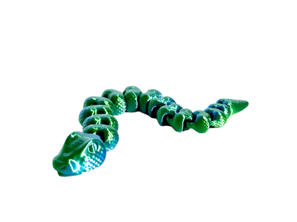 A shiny green alligator toy curves from left to right, its segmented body displayed against a solid black background.