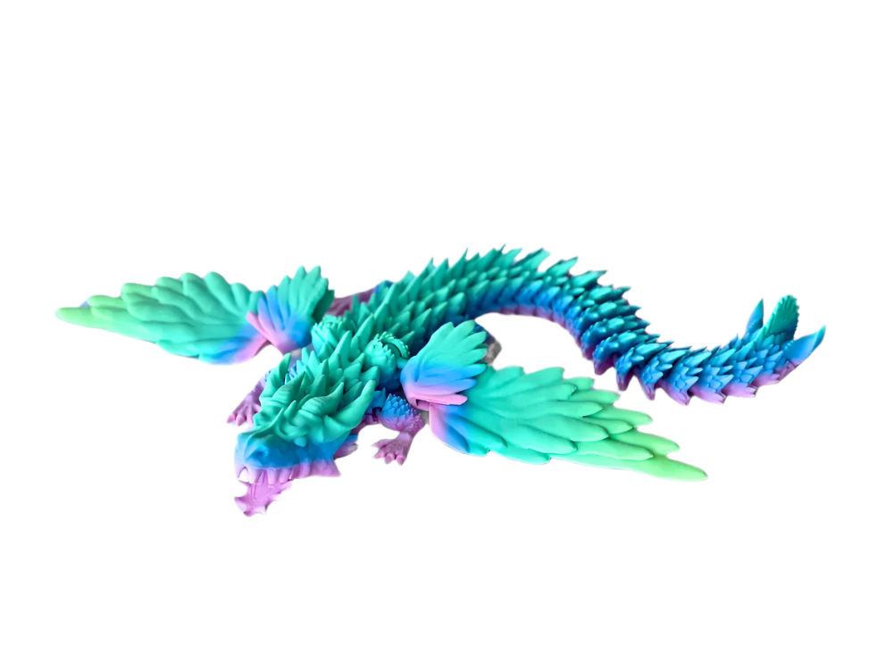 A segmented, pastel dragon with wings is lying on a black surface. It has a curly tail and feathery wings.