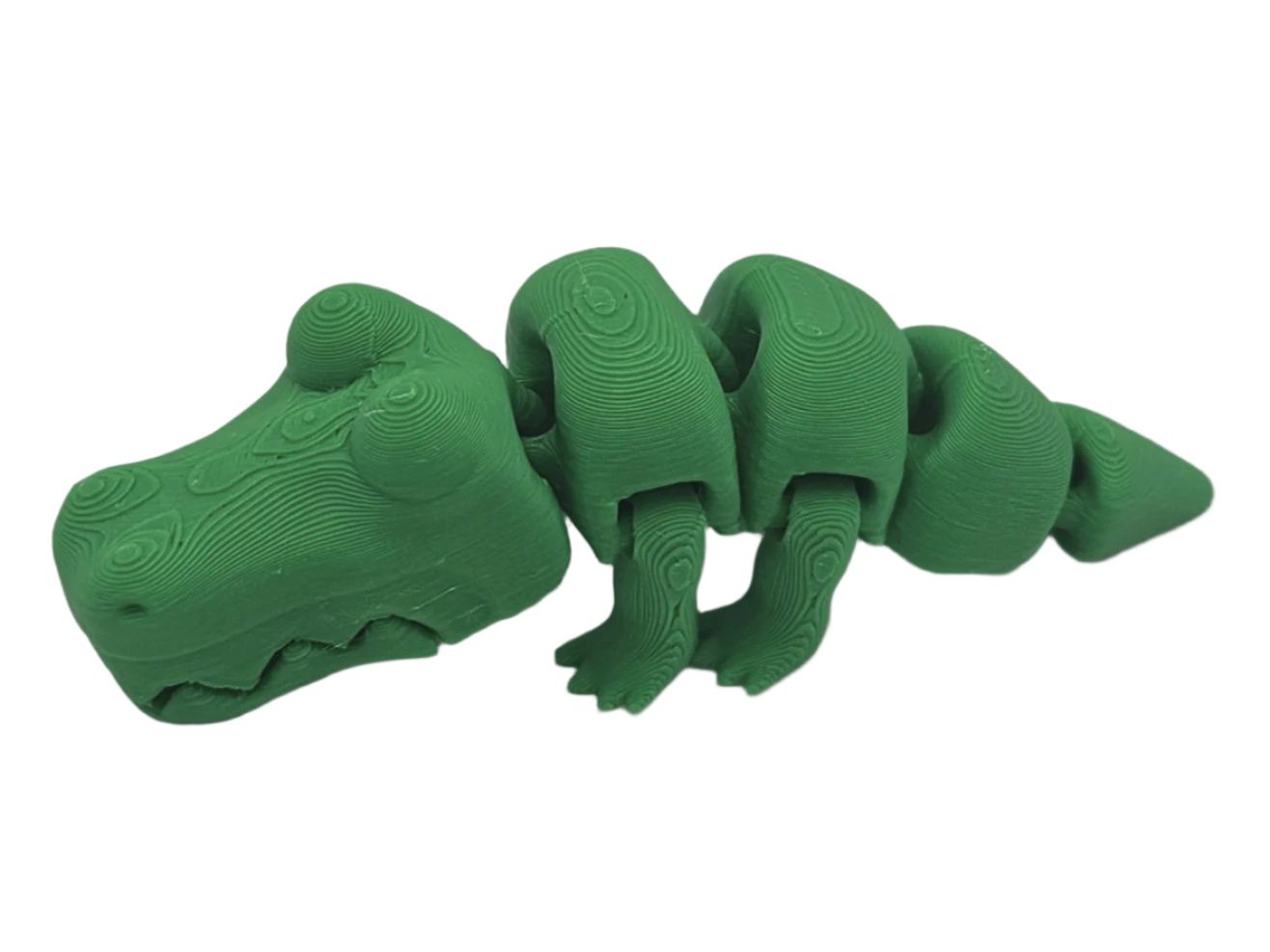 A green, articulated alligator toy rests on a black surface. Its segmented body features a faux-wood grain pattern, giving the toy a unique, textured appearance.