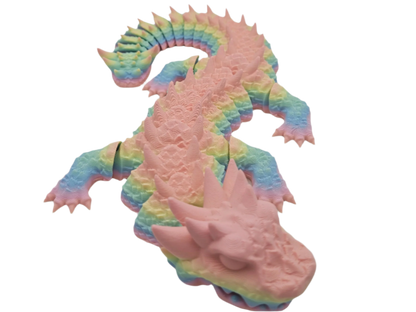 A rainbow-colored dragon lies in a prone position, its limbs splayed out and its head facing downward. The background is black.