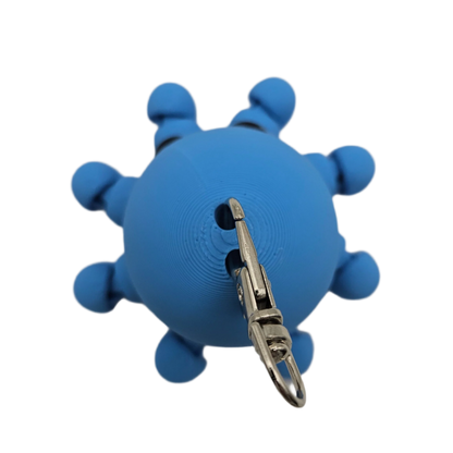 A blue, spherical toy with nub-like appendages and a key-chain clasp hangs against a black background.