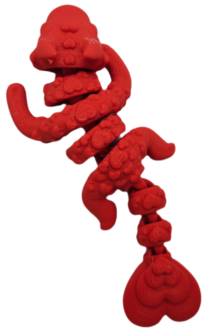 A red, vertically-oriented sculpture, composed of stacked, undulating shapes reminiscent of stylized organs or abstracted hearts, is isolated against a solid black background.
