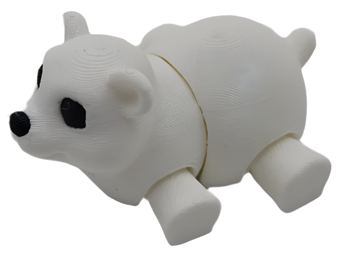 A 3D-printed white bear figure with black eyes and nose lays on a black surface. The bear's body is segmented at the midsection.