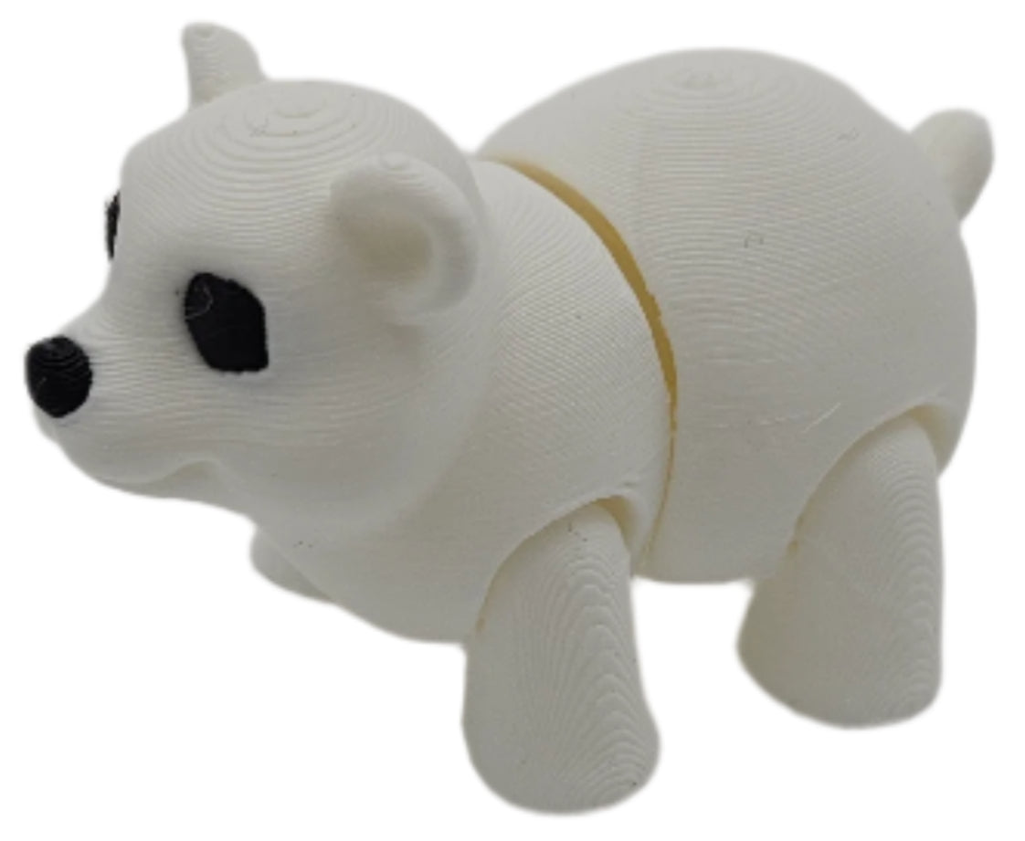 A white, segmented polar bear figurine stands on a white surface. The figurine appears to be 3D printed, showing striations from the printing process.