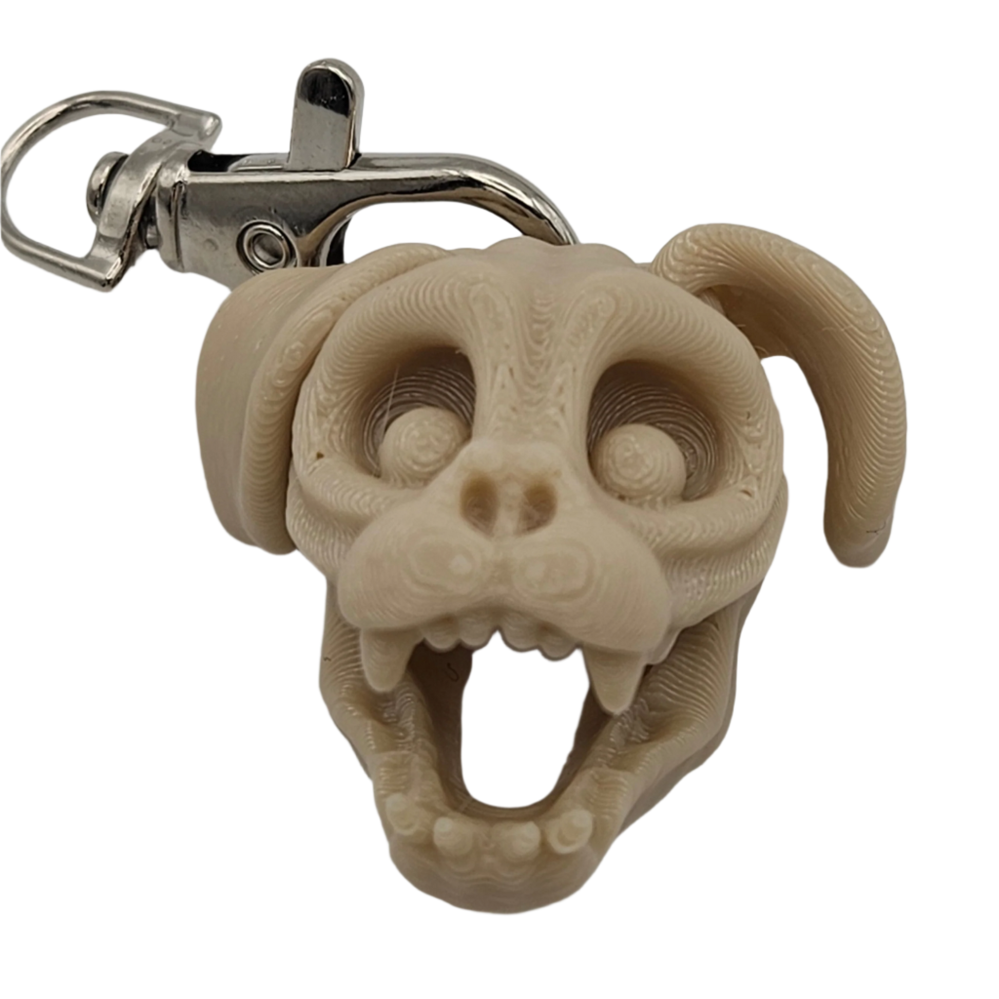 A stylized, beige dog skull keychain with a metal clip shows teeth in an open mouth. The head and ears are rounded, and its eyes are hollow.