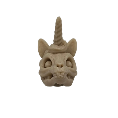 A tan-colored cat skull with ears and a unicorn horn sits against a solid black background.