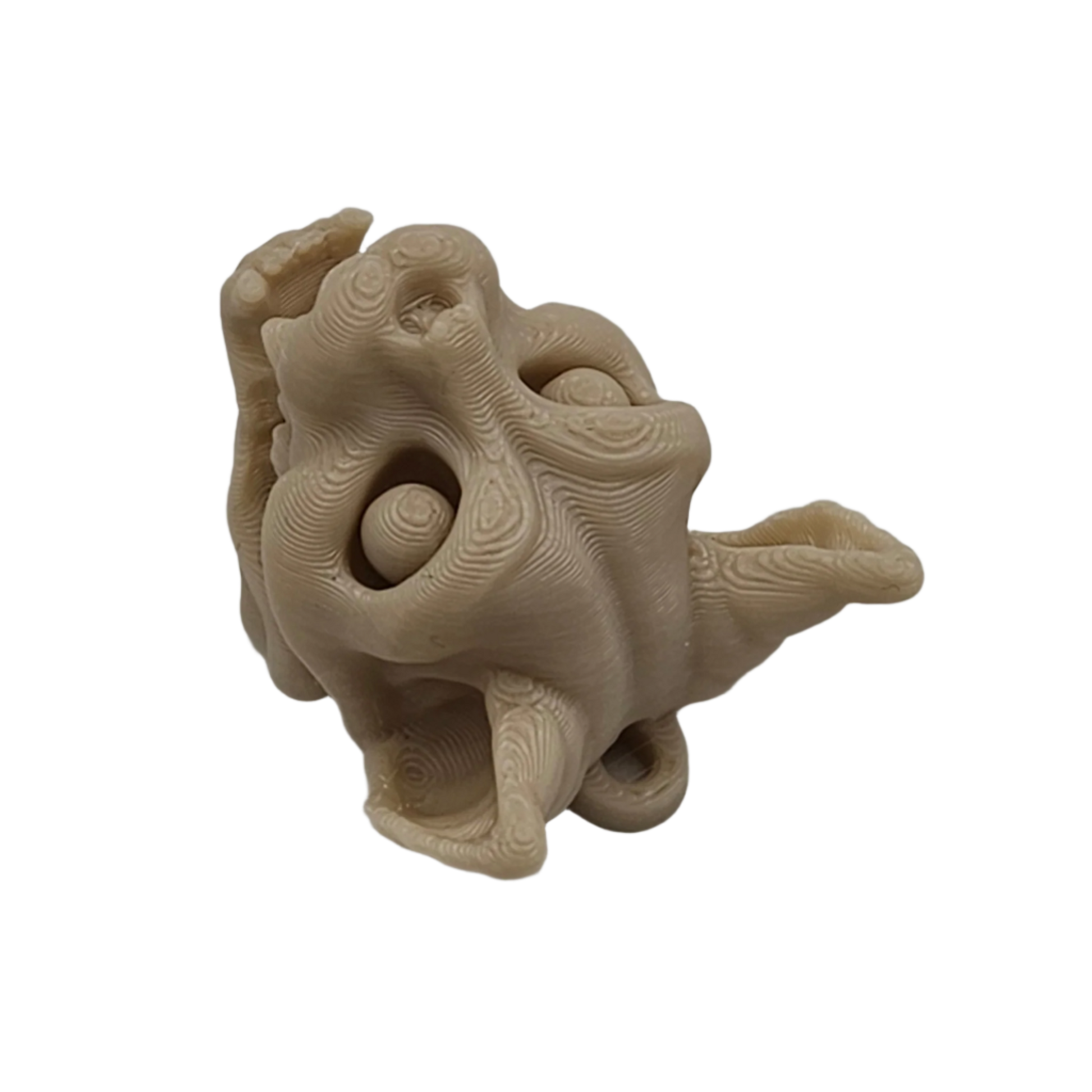 A tan, topographically textured sculpture of a distorted, dragon-like head is centered in the frame, with a gaping mouth, bulbous eyes, and flowing ear-like forms, against a solid black background.
