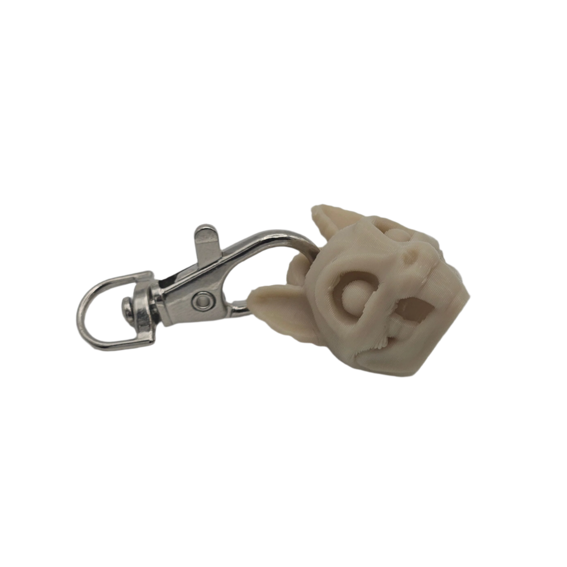 A pale cat skull keychain hangs horizontally against a black background, the skull's right side attached to a silver clasp.