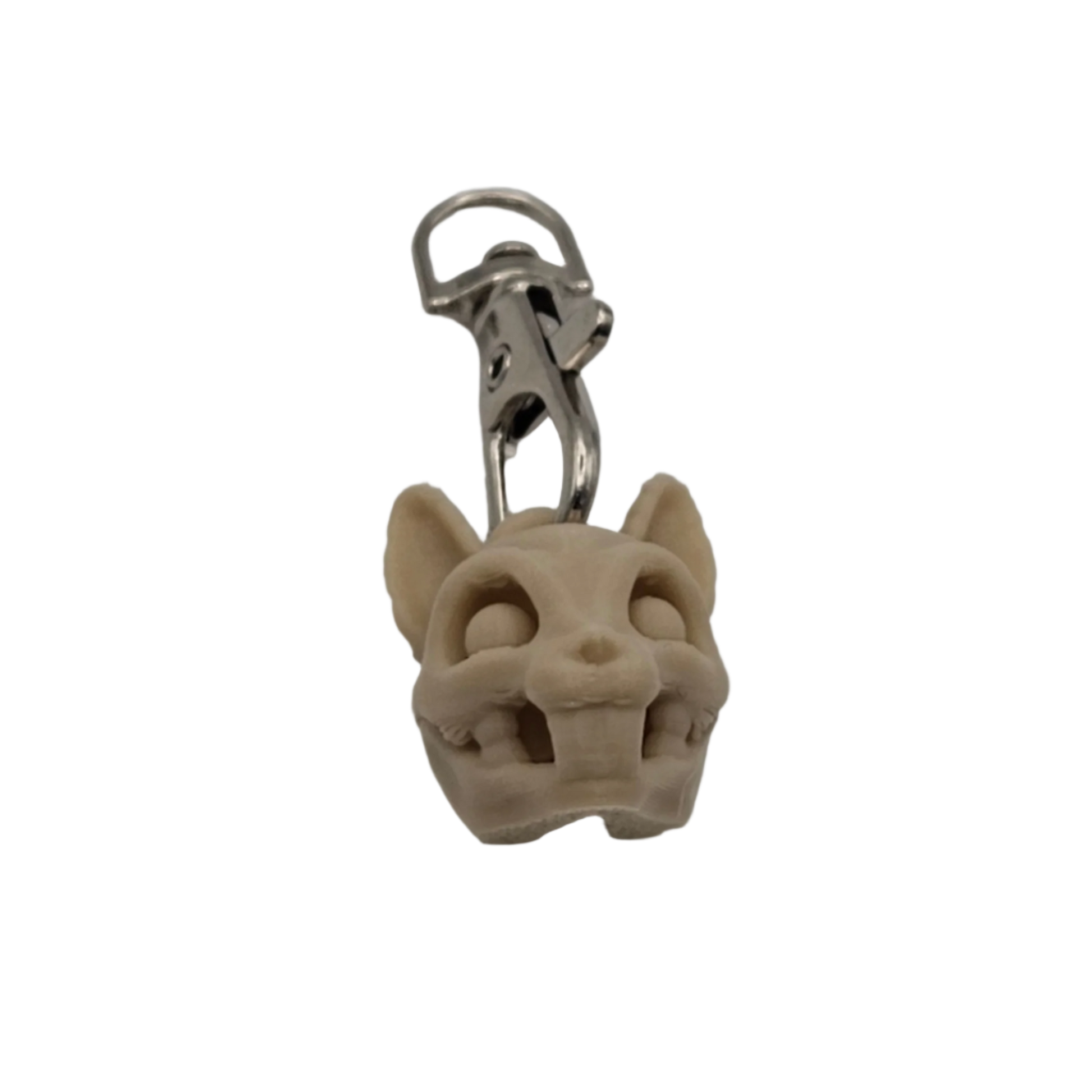 A cartoonish animal skull, made of pale tan material, dangles from a silver-colored metal clip in a black background.