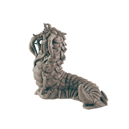 A segmented worm monster with tentacles and claws raises its head. The creature rests on a rocky surface against a dark blue background.