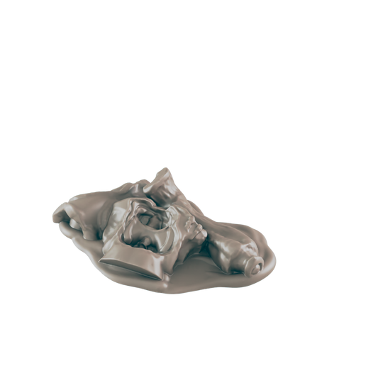A crumpled, light-brown figure, perhaps wax or clay, rests in a pool of the same substance, all against a stark black background.