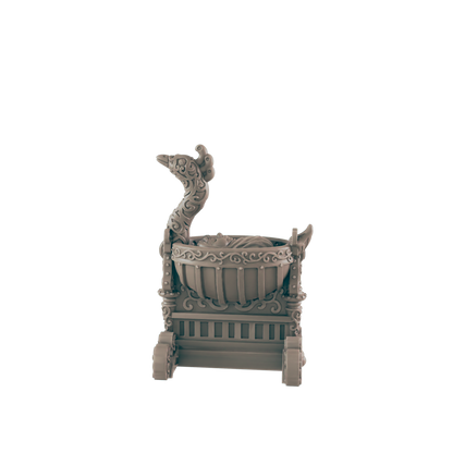 An ornate, miniature, wheeled baby carriage sits stationary against a black background. The carriage has scrollwork detail and a tall decorative swan neck ornament at one end.