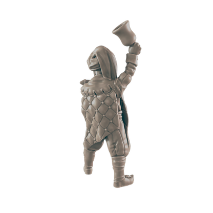 A miniature figurine, appearing to be a hooded figure in quilted clothing, raises a bell overhead against a black background.