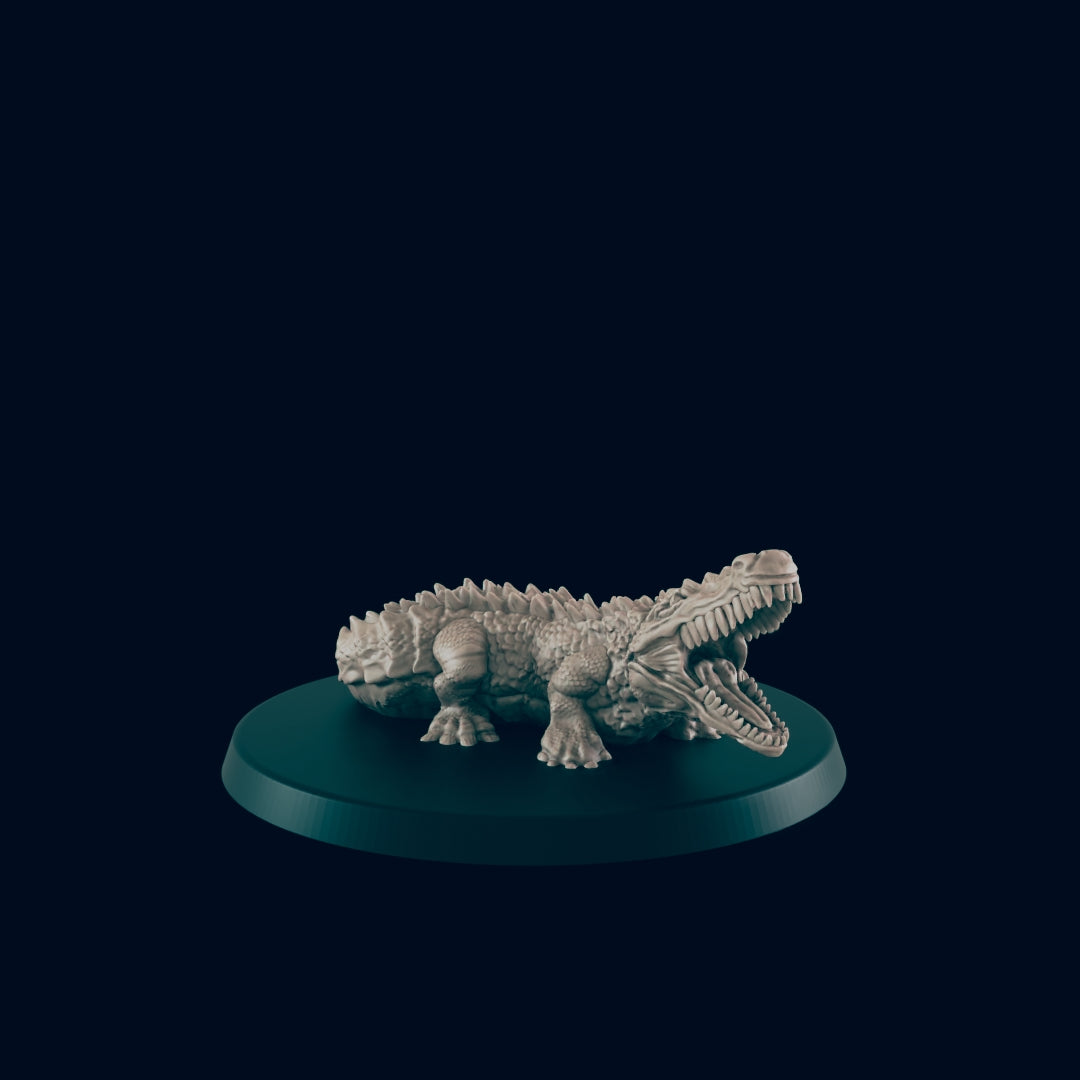 A monochromatic alligator miniature sits on a small, flat, round, teal base. The alligator's mouth is open wide, revealing many teeth. The background is a solid dark teal.