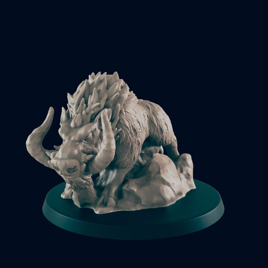 A boar-like creature figurine, crouching on rocks, is displayed on a dark circular base.