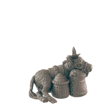 A donkey figurine rests against two sacks; one woven, one barrel-shaped, against a dark background.