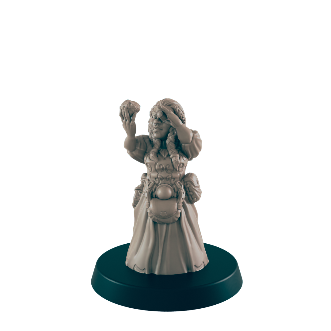 A miniature female figurine, holding up a small object and shielding her eyes, stands on a dark circular base.