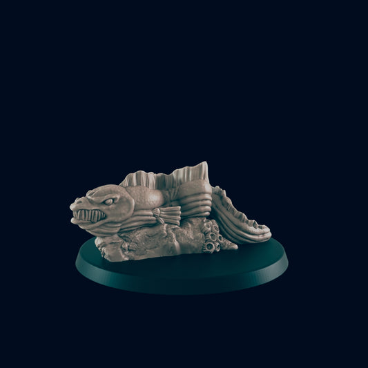 A sculpted fish rests on a rocky base. It is positioned on a dark circular platform against a black background.