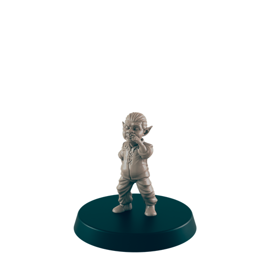 A small, tan goblin figurine stands on a dark circular base, covering its mouth, seemingly in contemplation or amusement against a plain dark background.