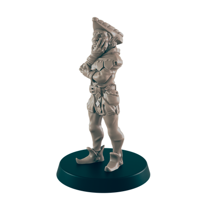 A miniature elf figurine stands pensively, hands clasped, on a dark circular base.  The elf wears a hat, jacket, and breeches.
