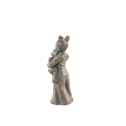 A sculpted girl hugs a teddy bear; she wears a long dress. The figurine stands alone against a black background.