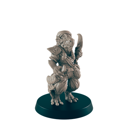 A miniature reptilian humanoid figure stands holding a curved blade, posed on a dark circular base against a dark background.