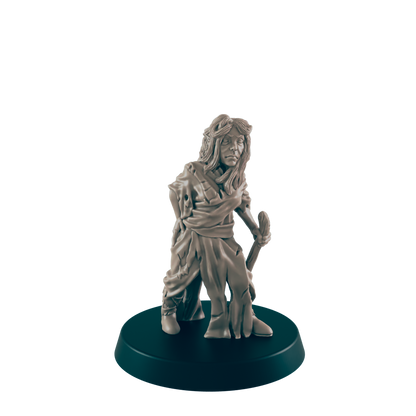 A miniature figurine of a woman, appearing weathered and holding a staff, stands on a dark circular base against a dark background.