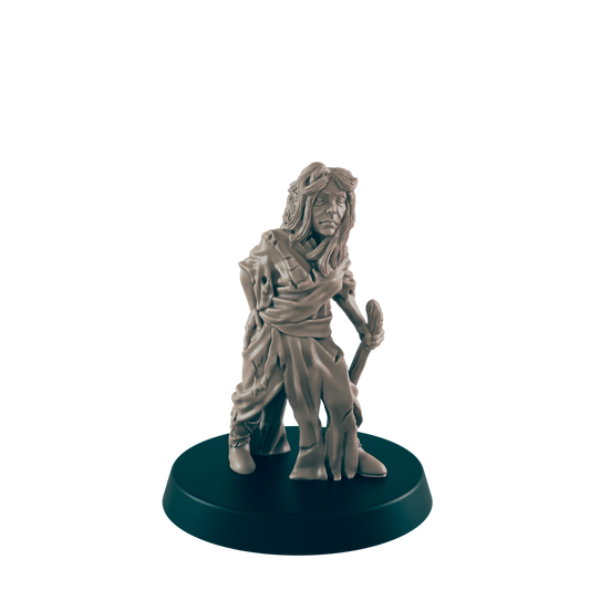 A miniature figurine of a woman, appearing weathered and holding a staff, stands on a dark circular base against a dark background.