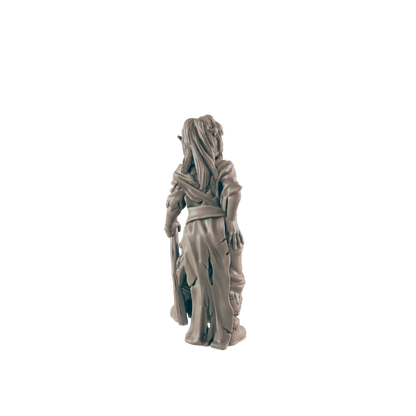 A miniature goblin figurine stands against a dark background; it holds a club and faces away.