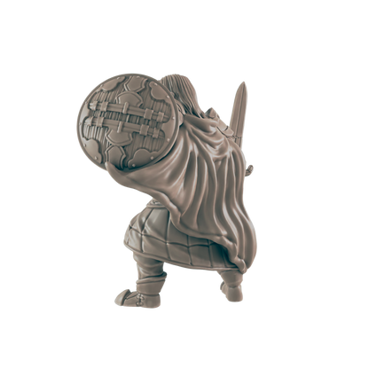 A miniature figure is crouched, holding a large round shield, with a sword visible behind the cape in a black surrounding.