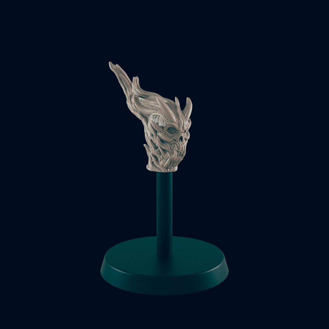 A skull-like miniature, with flame-like protrusions, stands on a dark circular base and a thin, dark cylindrical stand against a dark background.